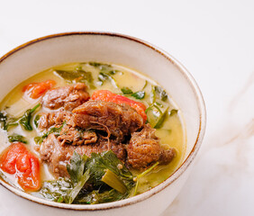 Savory beef stew with fresh herbs and vegetables in a rustic bowl