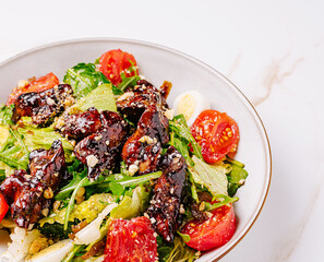 Colorful vegetable salad featuring grilled chicken and cherry tomatoes