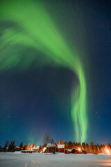 Northern lights glowing over Lapland’s snowy wilderness, a magical spectacle of nature’s beauty.