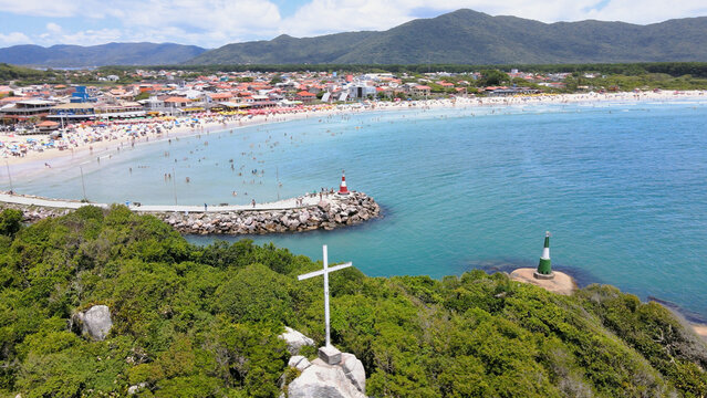 Panoramic aerial view of Barra da Lagoa Beach in Florianópolis Santa Catarina Brazil on a beautiful sunny summer day with rocky shores with jetty and estuary of Lagoa da Conceição
