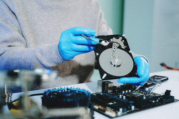 Obraz premium Technician repairing inside of hard disk drive by screwdriver. the concept of data, hardware, technician and technology. computer hardware, repairing, upgrade