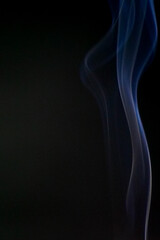 Ephemeral Dance: A captivating abstract display of gracefully curling smoke, its ethereal wisps painted with delicate hues of blue, evoking a sense of tranquility and mystery against a dark backdrop.