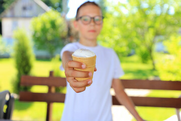 a teenager savoring a delicious ice cream cone while surrounded by the beauty of nature on a warm summer day.