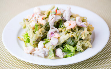 This vibrant seafood salad served with crispy morning glory reflects the harmony of Thai cuisine, combining shrimp, fish, and fresh vegetables.