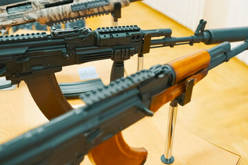Kalashnikov assault rifle on display stand at an exhibition.