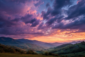 Obraz premium Majestic sunset illuminates rolling hills with vibrant colors in a serene landscape, capturing the tranquility of nature at dusk over open fields and distant mountains