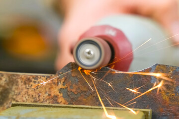 Obraz premium Grinding small parts on knife using a rotary tool with a grindin