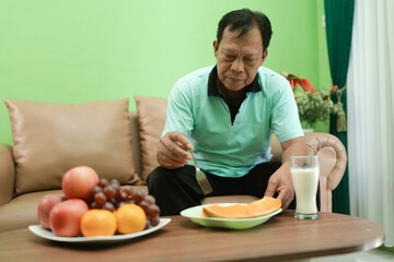 A man enjoys a delicious, nutritious meal of fresh fruits and milk in a cozy setting