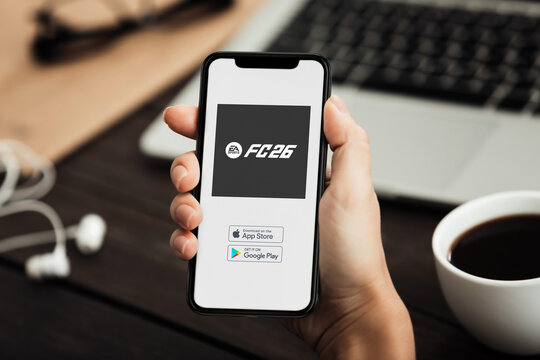 Businessman downloading ea sports fc 26 on mobile phone