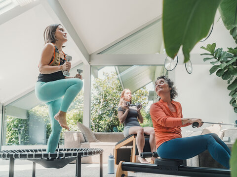 Mother and daughters exercising together at home in the living room