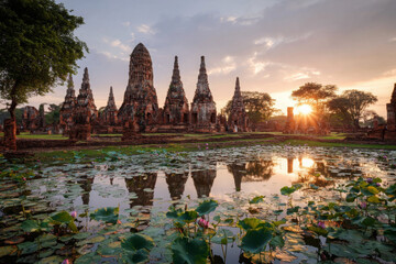 Obraz premium Ayutthaya ancient temple ruins stand serene at sunset, reflecting in lotus pond