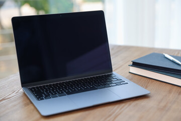 Fototapeta premium Home workspace. Laptop and stationery on wooden desk indoors, closeup
