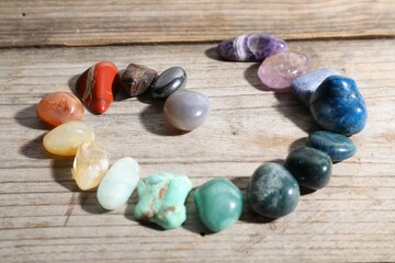Many different healing stones on wooden table, closeup