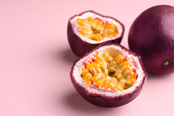 Fresh passion fruits on pink background, closeup. Space for text
