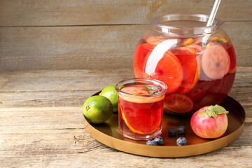 Tasty punch and fruits on wooden table, space for text. Refreshing drink