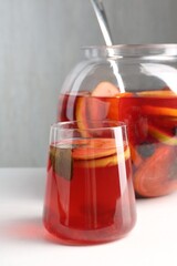 Tasty fruity punch on white table. Refreshing drink