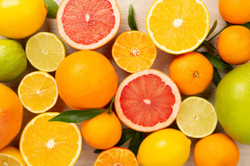 Different citrus fruits on wooden background, top view