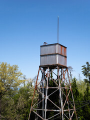 山に立つ錆びた古い給水塔