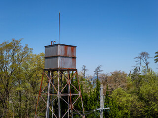 山に立つ錆びた古い給水塔