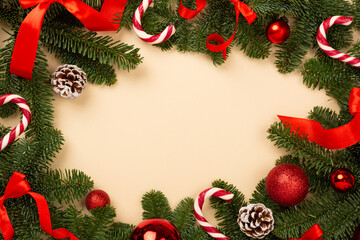 Christmas tree branches with festive decoration on color background, top view