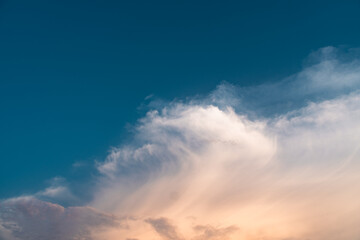 Obraz premium Dramatic summer clouds float peacefully across the vast blue skies, cinematic cloudscape at sunset 4k wallpaper 