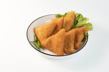 Risol Mayo segitiga or Triangle Risol mayonnaise served in a white bowl with fresh lettuce and green chili on white background. Showcasing a savory Indonesian snack with breadcrumb coating