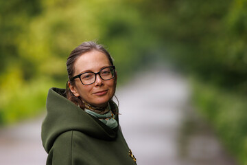 Woman enjoying a peaceful moment outdoors in a park on a sunny day surrounded by greenery