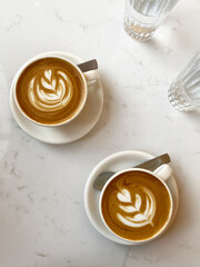Flat White Coffee with Latte Art Served for Two on White Marble Table. Drinking Coffee.