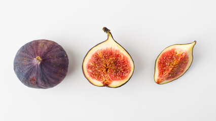 Fresh figs whole, part and cut isolated on light background, horizontal. Concept of healthy eating, natural products and vegetarian food.