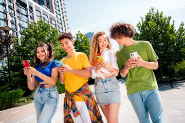 Friends enjoying the outdoors while sharing moments on their smartphones in a vibrant urban setting