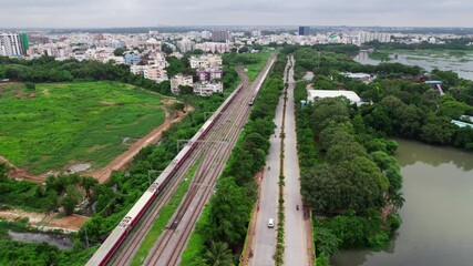 Aerial view of a train running parallel to PVNR Marg, with city view and greenery. day time, moving up, jib shot, drone shot, 4k.