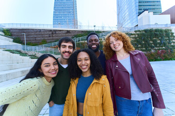 Happy multi ethnic students smiling together in a modern city park