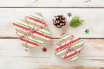 Striped Christmas gift boxes on wooden background, top view