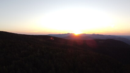 Sunset Over Mountain Range and Forest – Aerial View Landscape
