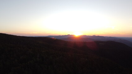 Sunset Over Mountain Range and Forest – Aerial View Landscape

