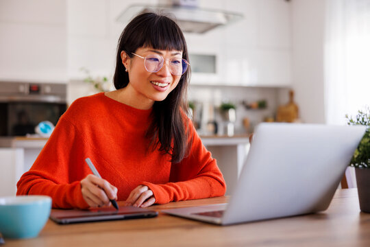 Web designer drawing using drawing pad while working remotely from home