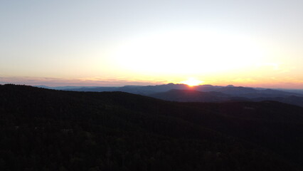 Sunset Over Mountain Range and Forest – Aerial View Landscape
