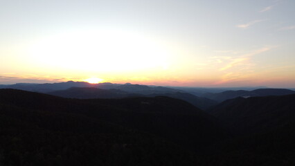 Sunset Over Mountain Range and Forest – Aerial View Landscape
