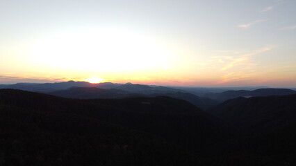 Sunset Over Mountain Range and Forest – Aerial View Landscape
