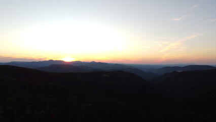 Sunset Over Mountain Range and Forest – Aerial View Landscape
