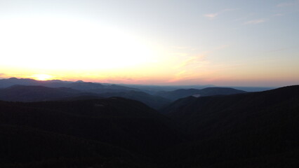 Sunset Over Mountain Range and Forest – Aerial View Landscape
