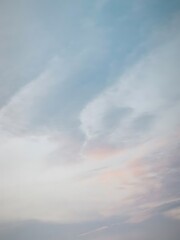 Soft pastel clouds in a light blue sky