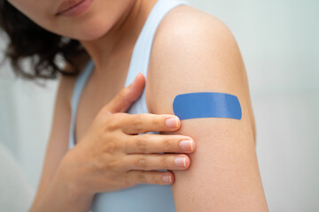 HPV, Human papillomavirus, Asian young woman receiving vaccine with blue bandage.