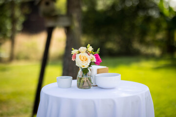 Une table de cocktail avec une nappe blanche et des fleurs dans un vase