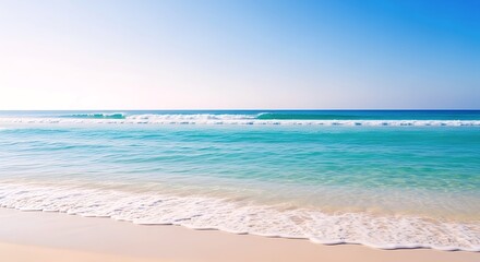 Fototapeta premium A Clear Turquoise Ocean Gently Laps At A Pristine Sandy Beach Under A Bright Blue Sky, Evoking Serenity And Tropical Relaxation.