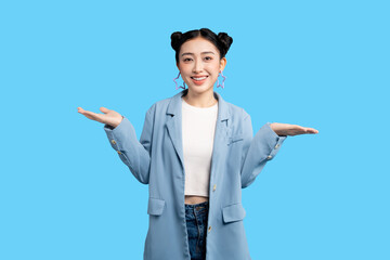  Happy Asian Young businesswoman in light blue suit poses with her palms outstretched, welcoming or presenting something