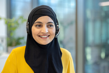 Smiling muslim customer service representative wearing headset in office