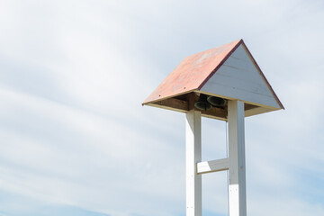 Historic church bell under a small wooden roof in a rustic village. Nordic charm, peaceful spiritual atmosphere, Christian tradition, and cultural heritage