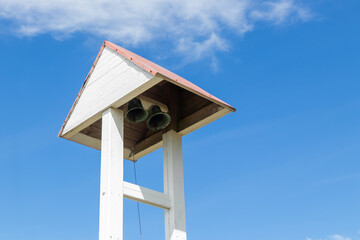 Historic church bell under a small wooden roof in a rustic village. Nordic charm, peaceful spiritual atmosphere, Christian tradition, and cultural heritage