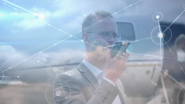 Animation of network of connections over businessmen using smartphone at the airport